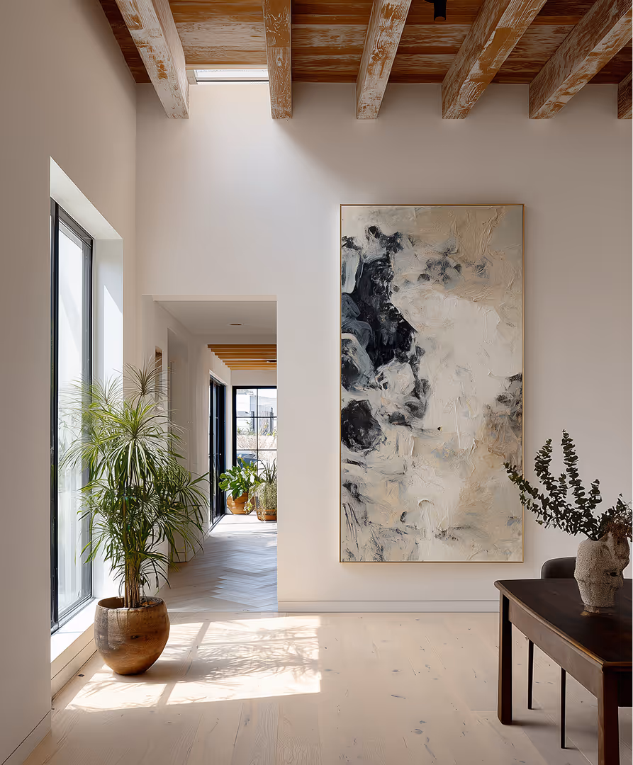 Modern interior hallway with wooden ceiling beams, large abstract painting, potted plants, and natural light from floor-to-ceiling windows.